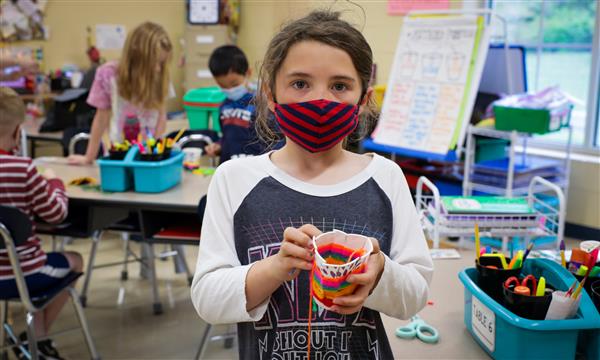 student creates woven craft
